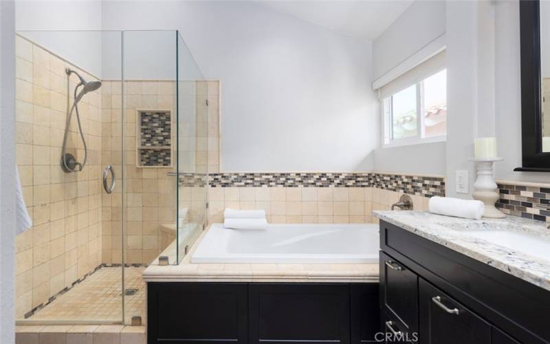 Glass-enclosed shower, and a separate tub in the primary bathroom.