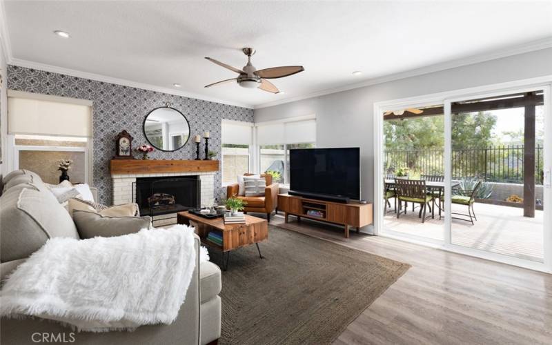 The cozy family room includes crown molding, recessed lighting, and a ceiling fan.
