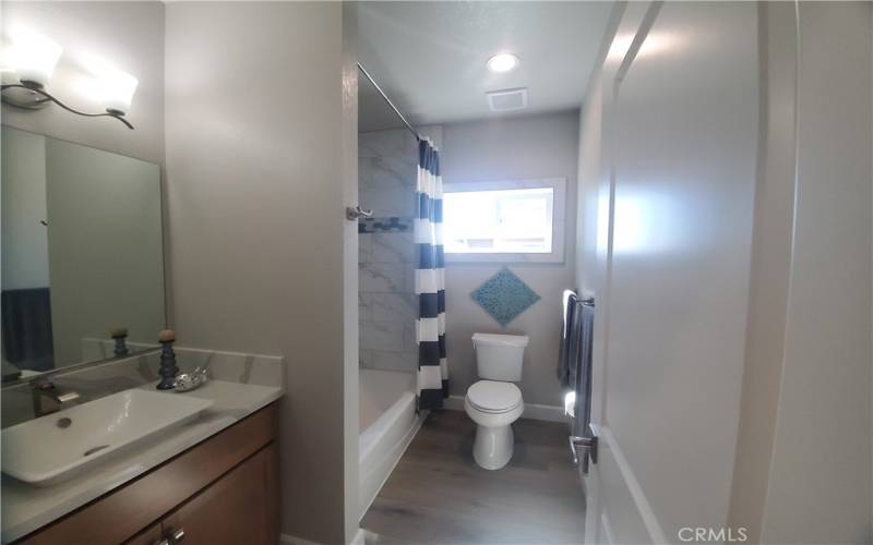 Guest bathroom with Quartz counter & custom tiled shower/tub.
