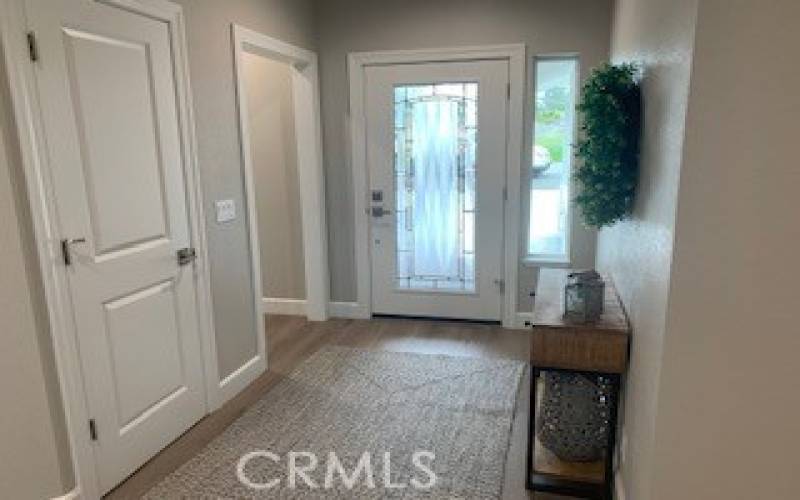 View of spacious entry way with leaded glass front door overlooking covered front porch.