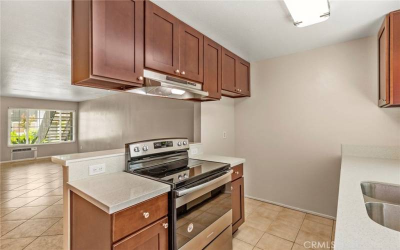 The updated kitchen features newer dark wood cabinetry, quartz countertops, new stainless steel  stove and hood, updated lighting....*Pictures are from previous listing but comments are current.