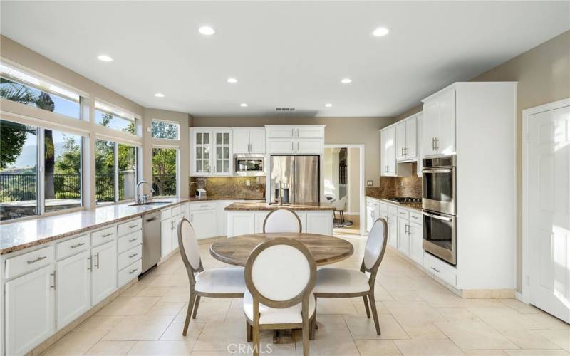 Kitchen offers stainless steel appliances and a walk-in pantry to the right side.