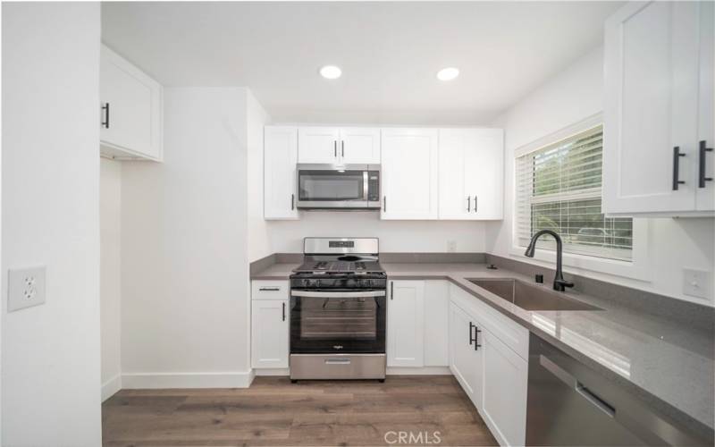 Your beautifully remodeled kitchen includes brand new range, microwave, dishwasher, garbage disposal, cabinets, quartz counter tops, vinyl plant flooring and hardware.