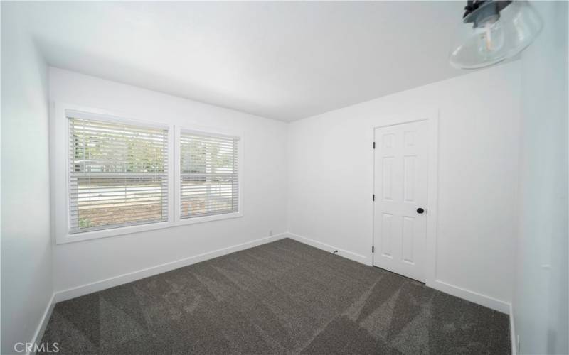 Bedroom 1 with new carpets, windows, lighting. door, and fresh paint!