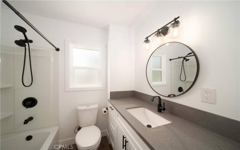 Completely remodeled bathroom includes new hardware, lighting, cabinets, quaartz counter tops, window and hardware.