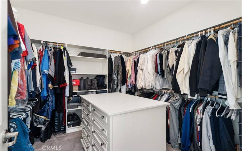 Tons of space in the walk in closet plus a center custom cabinet makes having a dresser in the primary bedroom unnecessary.