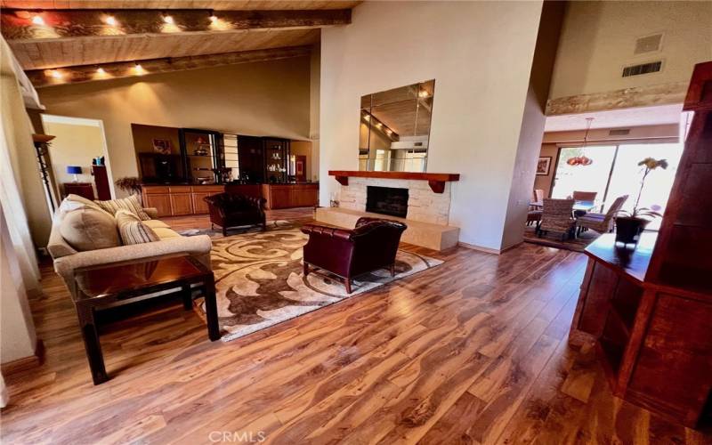 Living room wood flooring a vaulted ceilings.