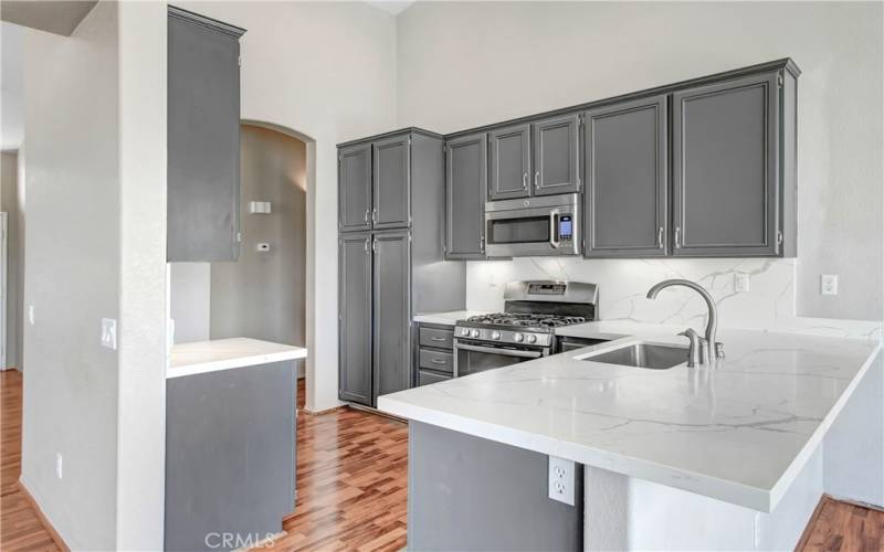 Kitchen rich in color with stainless steel appliances. Upgraded quartz counter tops with full quartz backsplash.