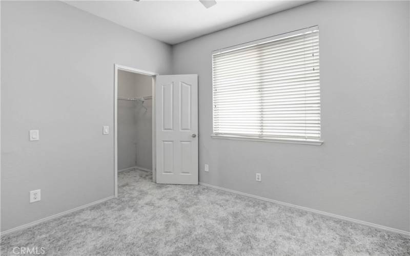 Third bedroom with new carpeting, ceiling fan and walk-in closet.
