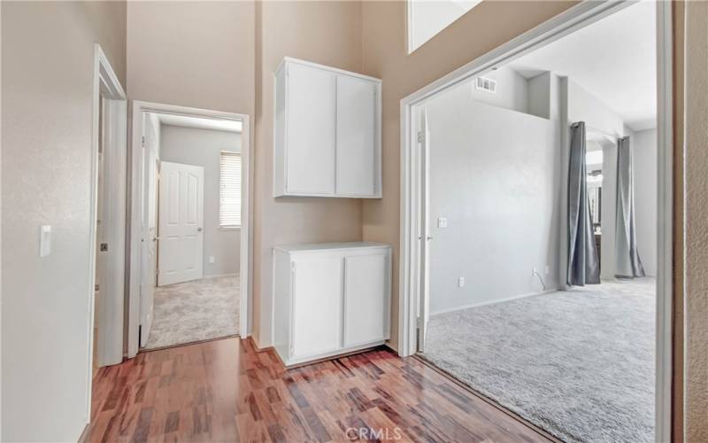 Hallway leading to master bedroom, back bedroom and hall bath.  Double door entry to master bedroom with decorative window above it.  Convenient storage cabinets here in the hall.