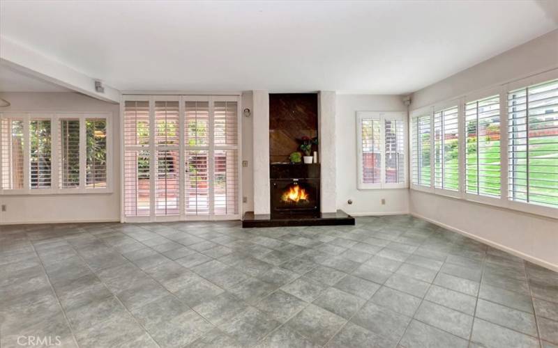 From entry towards sliders to patio. Plantation shutters good condition and open to beautiful green views.