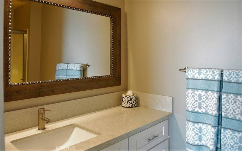 Quartz countertops and white bathroom vanities.