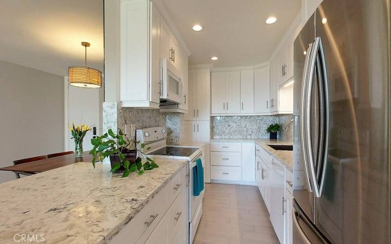 Kitchen cabinets with quartz countertop and backsplash.
