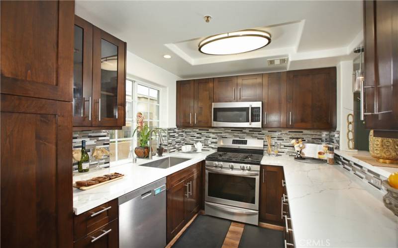 Updated kitchen includes stainless steel appliances, custom cabinetry and granite countertops.