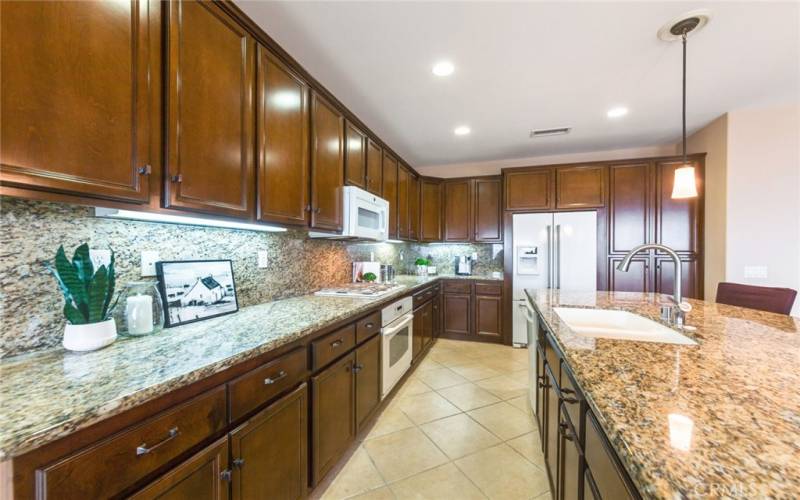 Plenty of Storage Cabinets in Entertainer Kitchen that opens to Great Room Living Lifestyle