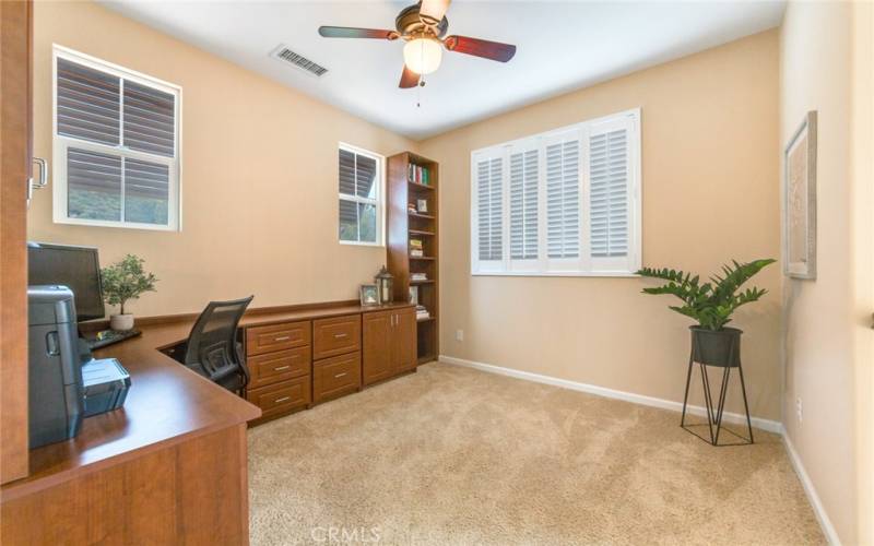 Office is open to downstairs Foyer, has Plantation Shutters, and great dark brown built-in Desk/Cabinets