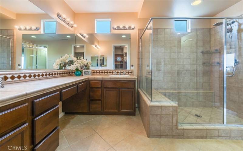 Primary Bathroom has Step-in Shower, Double-Sink Vanity and Decorative Tile treatments