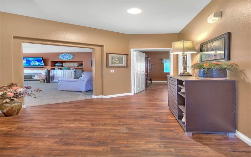 Hallway leading towards garage, bathroom, and downstairs room.