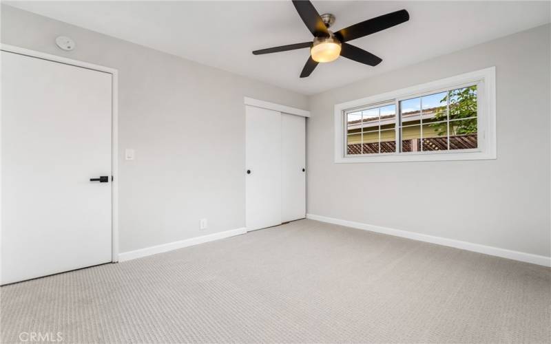 Relax in the primary suite with it's updated ceiling fan and cozy new carpet.