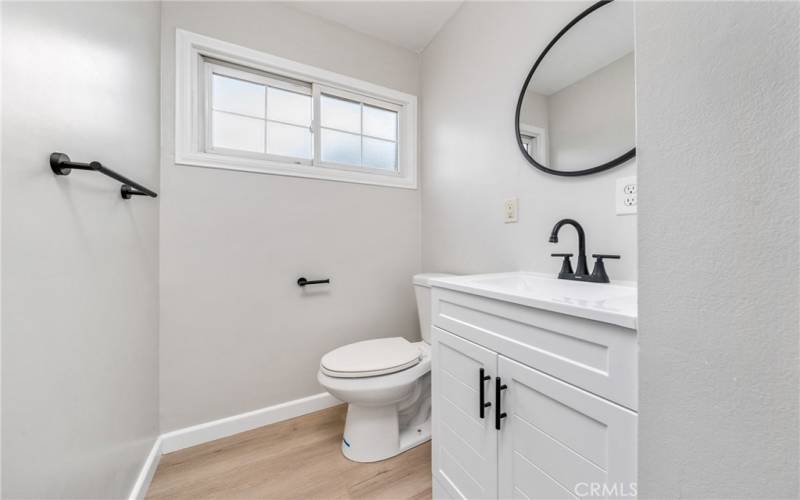 The secondary bedrooms share a nicely remodeled 3/4 hallway bathroom with a shower, matte black finishes, and a new vanity, light fixtures and laminate floors!