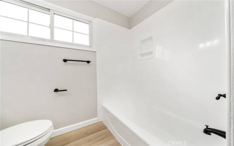 Matte black fixtures create a sleek, modern look in the hallway bathroom.
