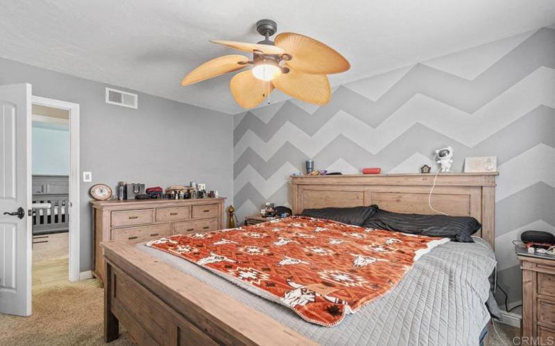 Primary Bedroom, decorative wall and ceiling fan.