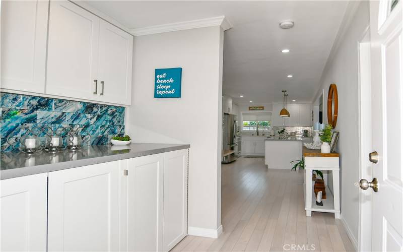 As you enter the house, laundry nook is to the left (in cupboards below). Primary bedroom is the door to the right