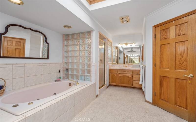 TWO vanities in the primary bathroom suite. LARGE tile shower can be seen in the corner.