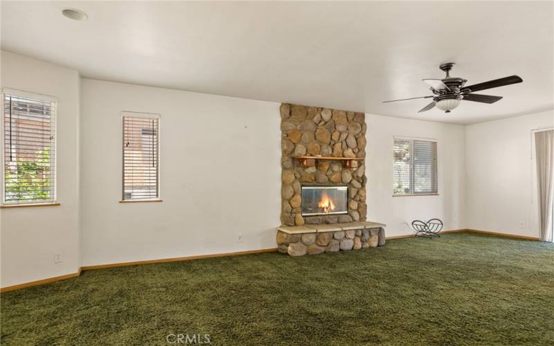 Living Room with Rock Fireplace and Ceiling Fan