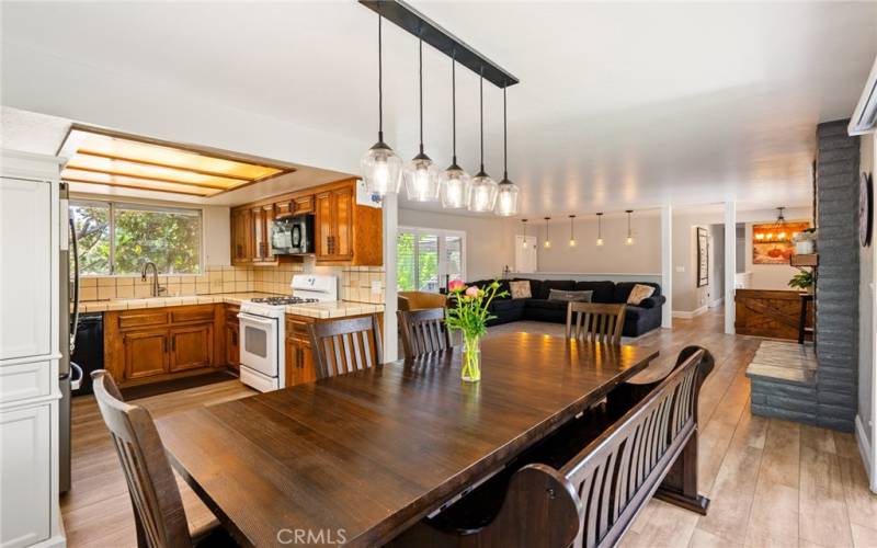 Adorned by a graceful drop lighting light fixture. The dining area is happily located between the living room and kitchen.