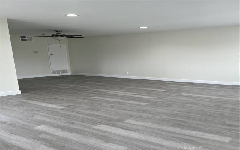 Spacious living room with new luxury vinyl flooring,  baseboards and recessed lighting.