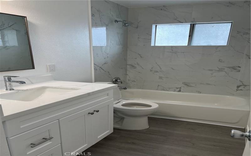 Completely upgraded bathroom with new vanity, quartz countertops, new toilet, tub/shower combo, new tile, fixtures and hardware.