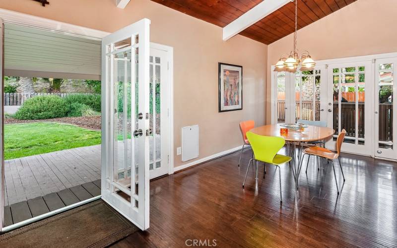 The dining room fittingly adjoins the kitchen and with its high wood-beamed ceilings, drop down lighting, and French doors that lead to the backyard deck with natural gas hook-up for a BBQ, it is perfect for any occasion.