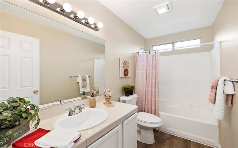 Guest bath with new lighting, toilet, medicine cabinet, faucet, & hardware