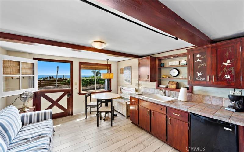 efficiency kitchen space with sofa and dining area in downstairs studio