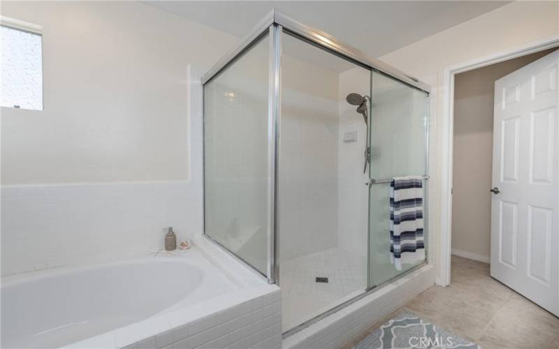 The primary bathroom has a soaking tub, walk in shower and separate toilet area though the door.