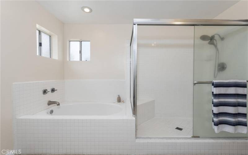 Separate soaking tub and large walk in shower in the primary bathroom.