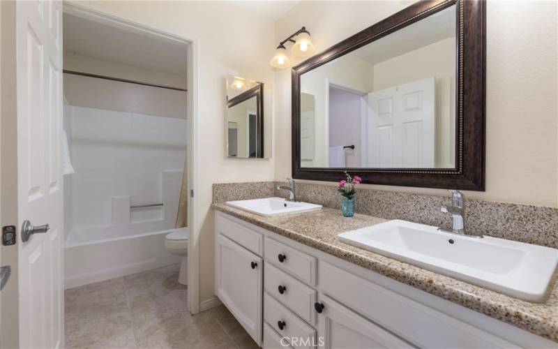 Upstairs hallway bathroom with dual vanities and granite countertop.