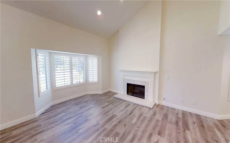 Living room has high cathedral ceiling with recessed lights