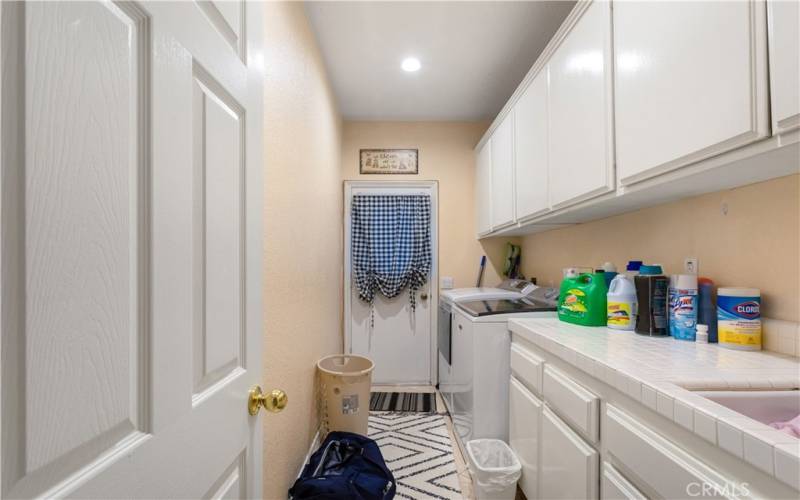 large laundry room with sink and side door.