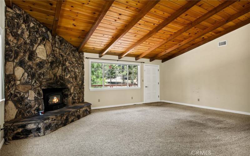 Main floor living room with knotty pine ceilings and rock wall - wood burning insert.