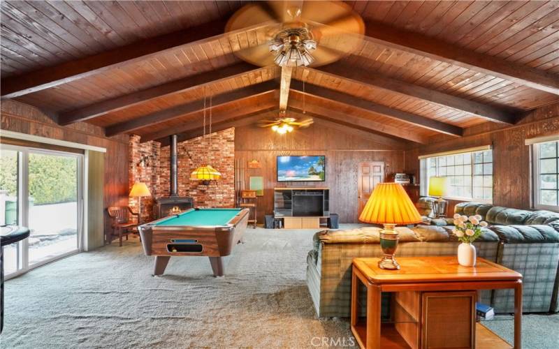 Spectacular Family room with vaulted wood beam ceilings, cozy stove fireplace and nature light from the large windows.
