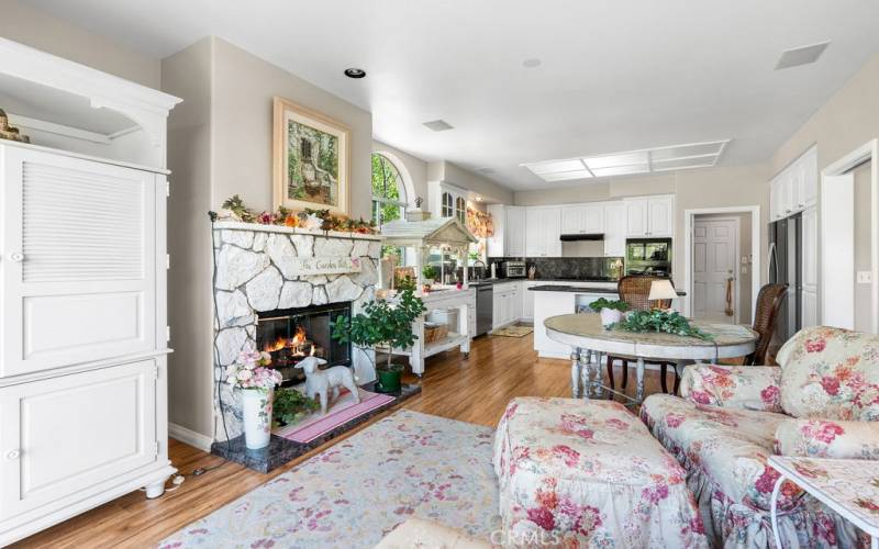 Integrated great room with another fireplace, creating a warm and inviting ambiance. Step onto the beautiful balcony overlooking the lush landscape, trees, an