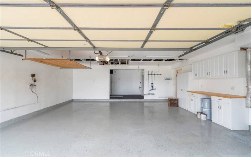 Super clean and spacious garage that boasts epoxy flooring, and an extended workshop area in back for extra space. Cabinetry for storage or linens, as well as a tankless water heater are included in the many upgrades.