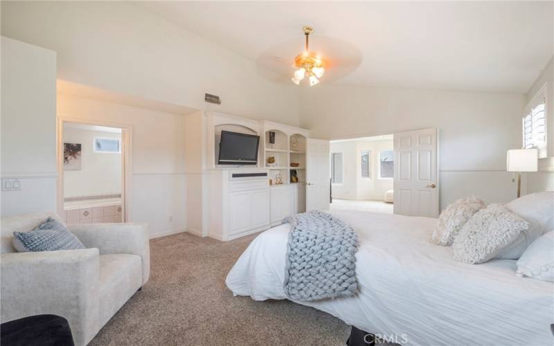 Large second floor primary suite with custom built-in entertainment center.