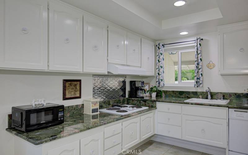 Kitchen features ample storage cabinets and a beautiful granite countertop.