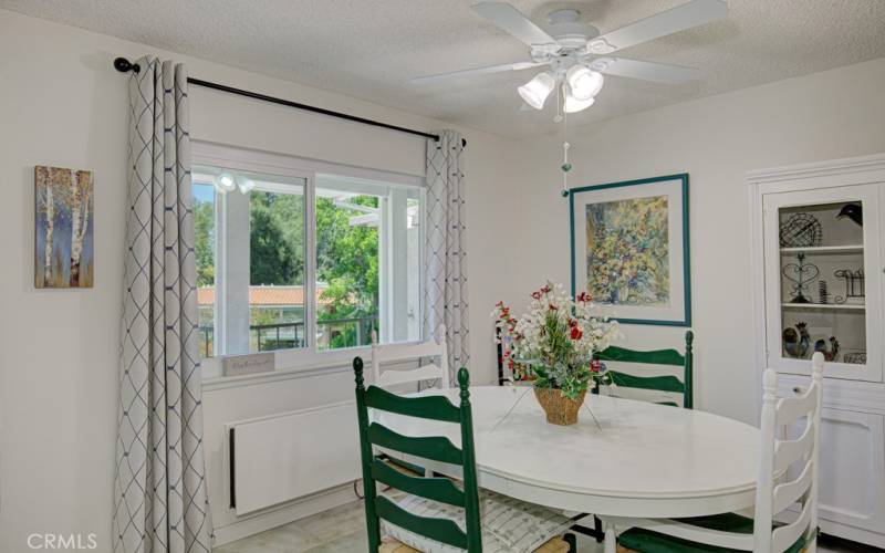 Dining area has a large view window and ceiling fan.