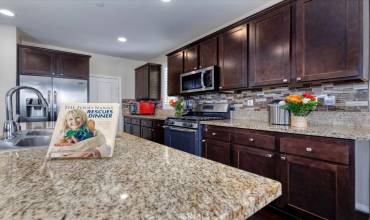 Kitchen with beautiful cabinetry, granite counters and stainless steel appliances.