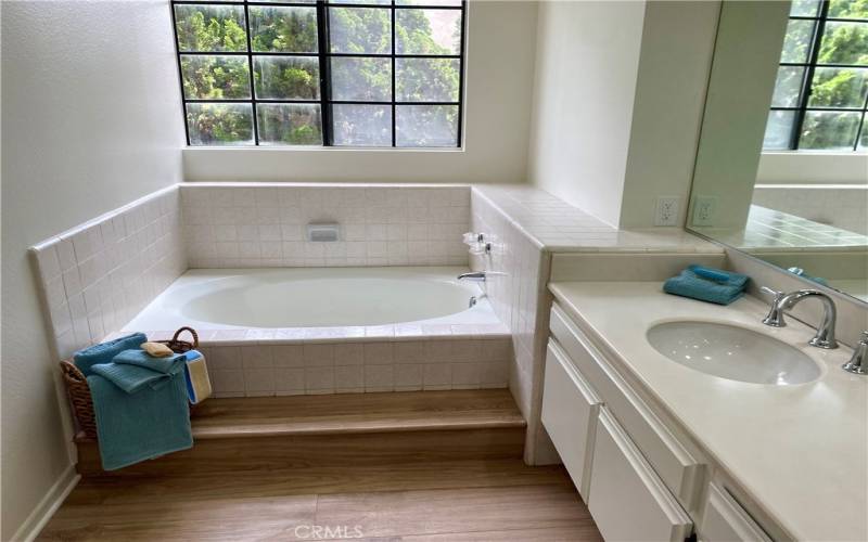 Primary bathroom with large soaking tub, dual sinks and a separate shower.
