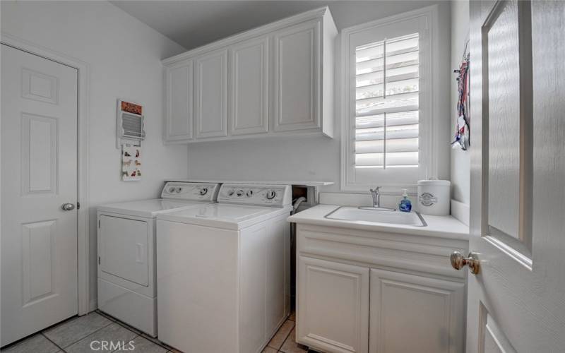Seperate Laundry room with utility sink, cabinets and storage closet